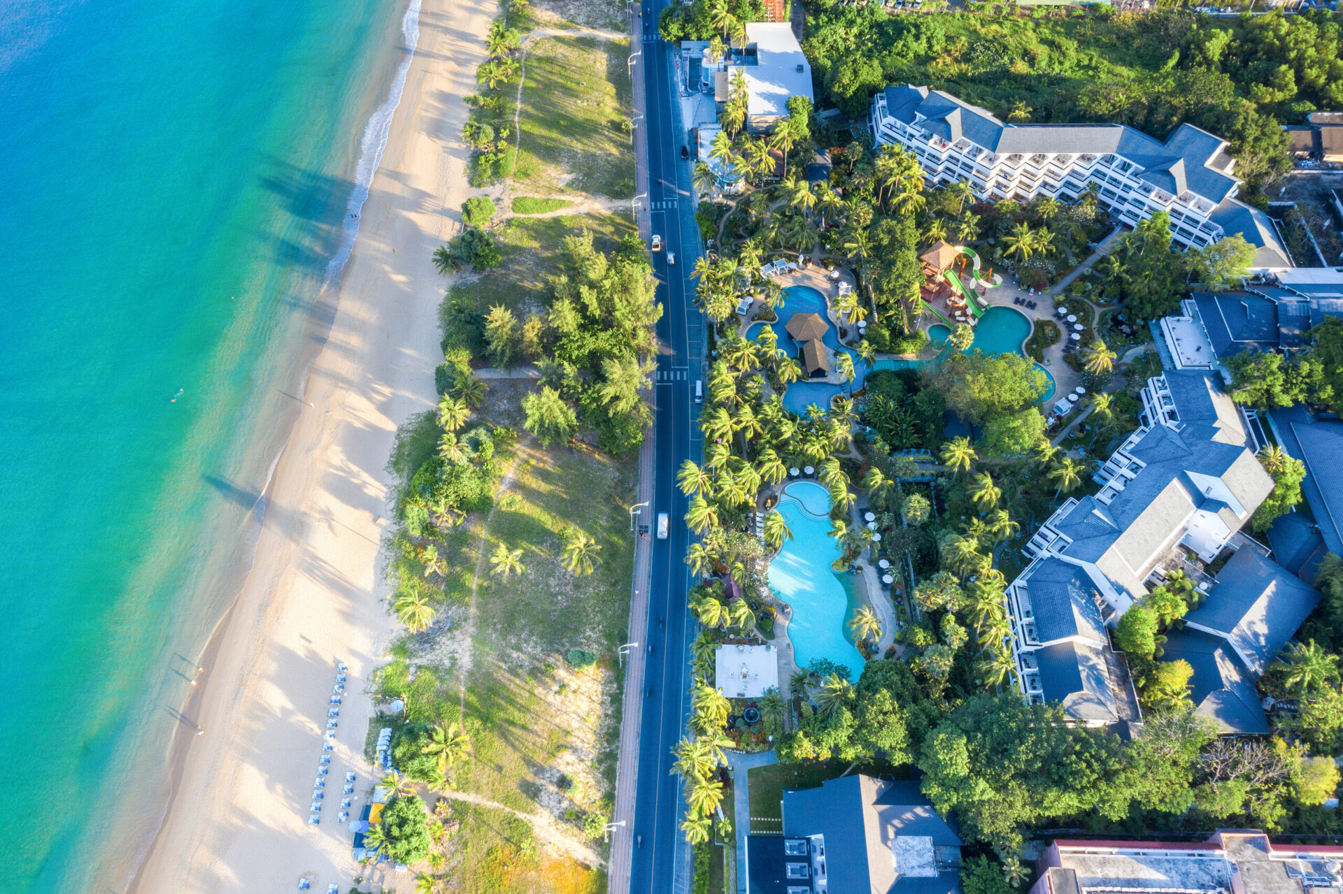 Luft Thavorn Palm Beach Resort med swimmingpool, palmetræer og strandudsigt. Luksus feriested i Thailand, ideelt til tropisk ferie.