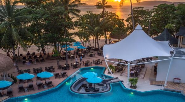 Resort ved Ao Nang strand med pool og parasoller, roligt oase ved solnedgang