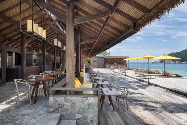 Haad Tien Beach Resort med træterrasse, borde og parasoller med udsigt til havet