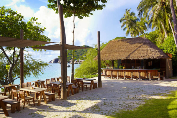 Haad Tien Beach Resort tilbyder en afslappende bar direkte på stranden med behagelige borde og stole, ideelt for dem der søger efter en