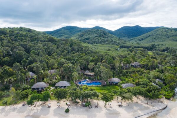 Luft et feriested ved stranden med frodigt grønt og individuelle bungalows, kystlinje med klart vand og sand i Koh Yao Yai Village Resort,