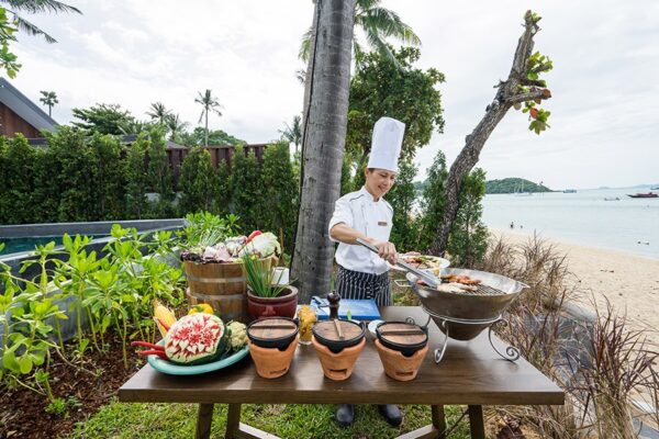 Kokken tilbereder mad ved bordet ved stranden i Peace Resort på Samui Beach